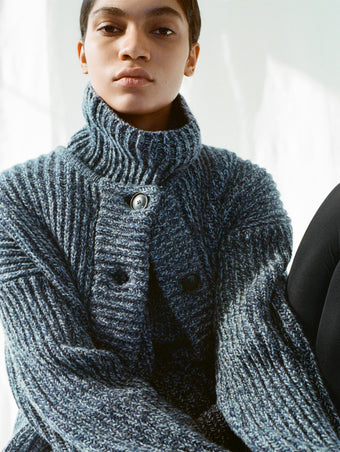 Cropped image of model wearing Azura Sweater and Ember Vest in Mouline Knits in ink melange