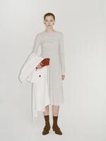 Image of model wearing Roger Layered Top in Gauzy Jersey in Pale Grey and Margo Skirt in Gauzy Jersey in Pale Grey, carrying Flip Shoulder Bag in Eel in rosewood, wearing Bronco Loafers in black.