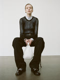 Image of a model wearing Allen Shirt in Crinkled Cotton Gabardine in sky blue, Willa Sweater in Sheer Mesh in black, carrying Slide Bag in white, and wearing Monogram Loafers in Eel in black.