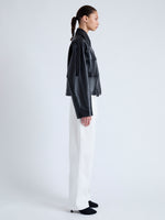 Side image of model wearing Dylan Jacket in Glossy Leather in black