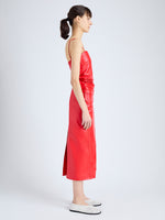 Side image of model wearing Delancy Dress in Glossy Leather in VERMILLION