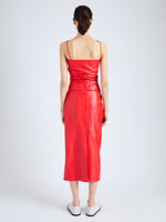 Back full length image of model wearing Delancy Dress in Glossy Leather in VERMILLION