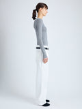 Side full length image of model wearing Cassidy Sweater in Superfine Merino Silk in LIGHT GREY MELANGE