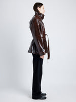 Proenza Schouler Side full length image of model wearing Finch Raincoat In Lacquered Cotton in DARK BROWN/BLACK