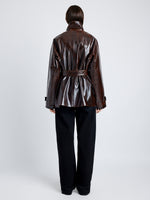 Proenza Schouler Back full length image of model wearing Finch Raincoat In Lacquered Cotton in DARK BROWN/BLACK