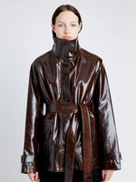 Proenza Schouler Detail image of model wearing Finch Raincoat In Lacquered Cotton in DARK BROWN/BLACK