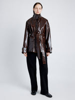 Proenza Schouler Front full length image of model wearing Finch Raincoat In Lacquered Cotton in DARK BROWN/BLACK