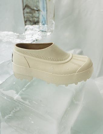 Image of SOREL x Proenza Schouler Caribou Mule in Chalk / Black sitting on block of ice