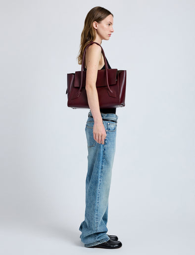 Front image of model wearing Tate Bag in Smooth Calfskin in dark red