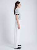 Side full length image of model wearing Powell Sheer Knit Top in OFF WHITE/BLACK