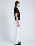 Side full length image of model wearing Powell Sheer Knit Top in BLACK/MARIGOLD