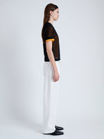 Side full length image of model wearing Powell Sheer Knit Top in BLACK/MARIGOLD