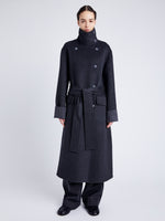 Proenza Schouler Front full length image of model wearing Constance Coat in Pinstripe Wool Cashmere in DARK GREY MELANGE buttoned withcoat belt and buttoned collar