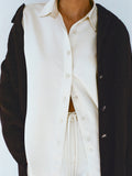 Cropped image of model wearing Raven Shirt and Magnus Pant in Satin in enoki