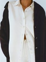 Cropped image of model wearing Raven Shirt and Magnus Pant in Satin in enoki