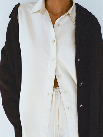 Cropped image of model wearing Raven Shirt and Magnus Pant in Satin in enoki