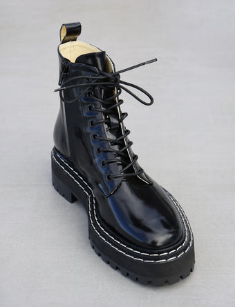 Proenza Schouler 3/4 front editorial image of Lug Sole Lace-up Boots in BLACK